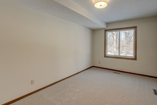 spare room featuring carpet floors and a textured ceiling