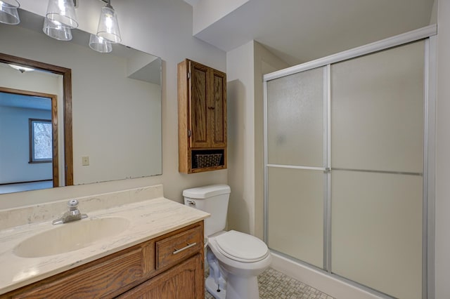 bathroom featuring vanity, toilet, and a shower with shower door