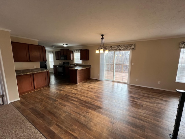 kitchen with dark hardwood / wood-style flooring, hanging light fixtures, a healthy amount of sunlight, and black appliances