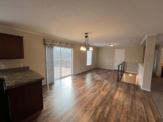 unfurnished dining area with a textured ceiling, ornamental molding, and dark hardwood / wood-style floors