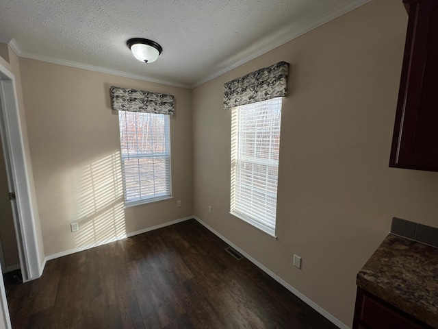 unfurnished dining area featuring a textured ceiling, dark hardwood / wood-style flooring, and ornamental molding