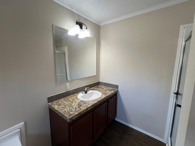 bathroom with ornamental molding, wood-type flooring, a textured ceiling, and vanity