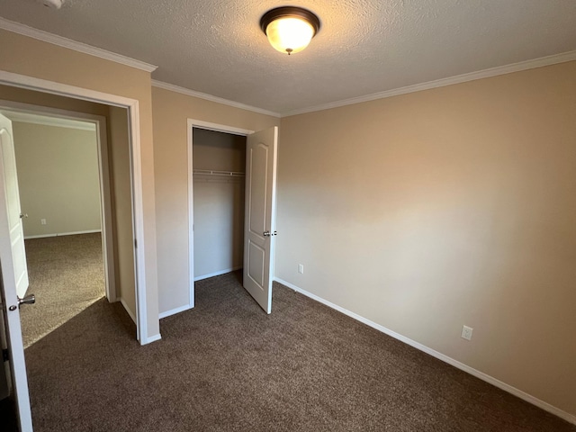 unfurnished bedroom featuring dark colored carpet, a closet, a textured ceiling, and ornamental molding