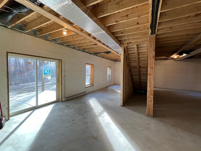 basement featuring a baseboard radiator and a wealth of natural light