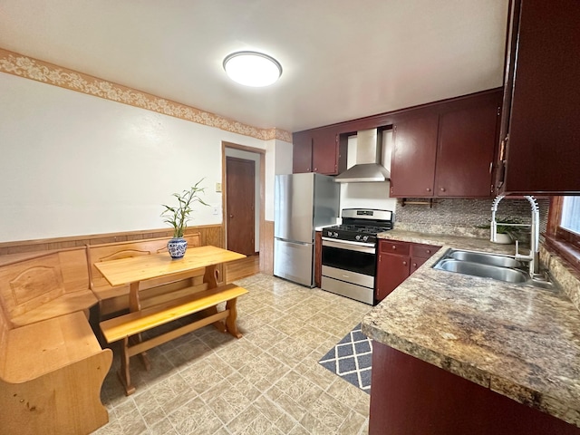 kitchen featuring decorative backsplash, sink, wall chimney range hood, and appliances with stainless steel finishes