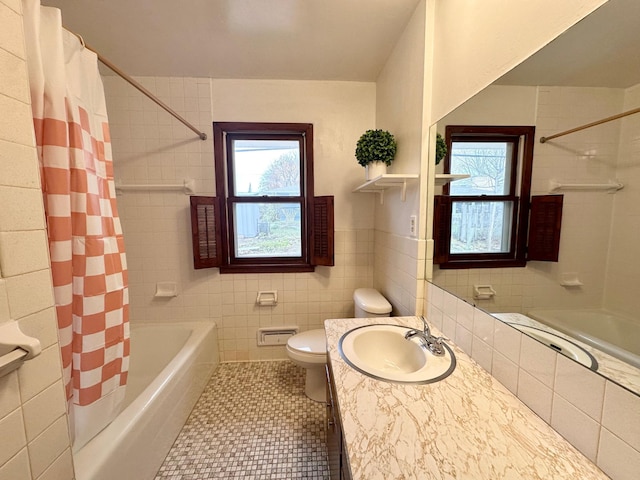 bathroom featuring tile patterned floors, vanity, tile walls, and toilet