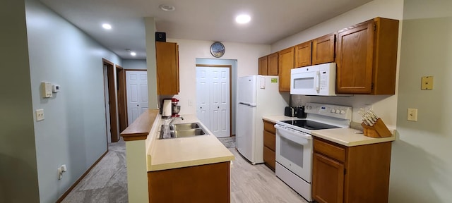 kitchen with sink, white appliances, and light wood-type flooring