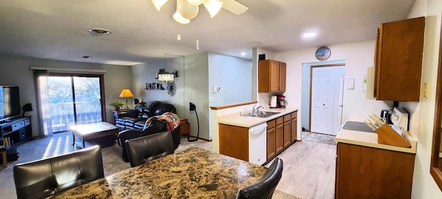 kitchen featuring dishwasher, sink, hanging light fixtures, and light wood-type flooring