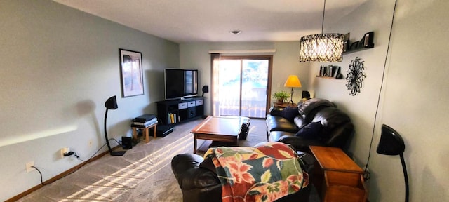 carpeted living room featuring a chandelier