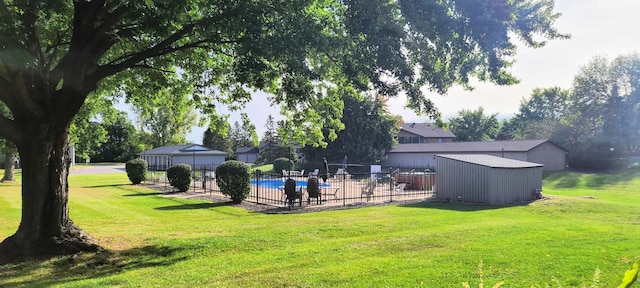 view of yard with a fenced in pool and a storage unit