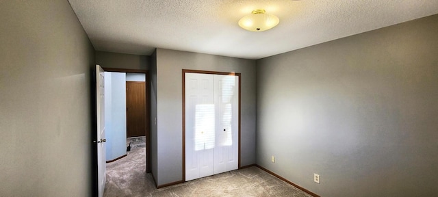 unfurnished bedroom with multiple windows, carpet, a textured ceiling, and a closet