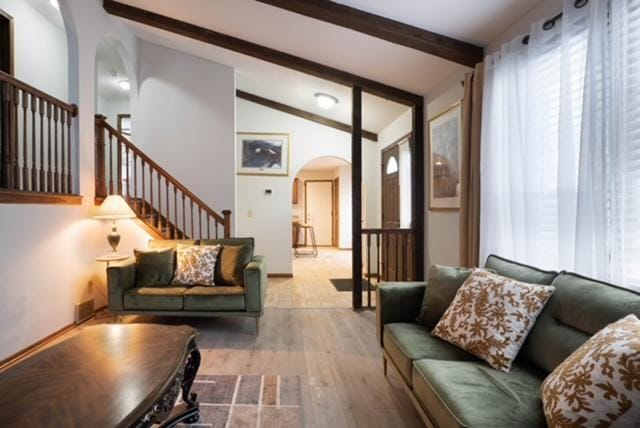 living room with wood-type flooring, beam ceiling, and high vaulted ceiling