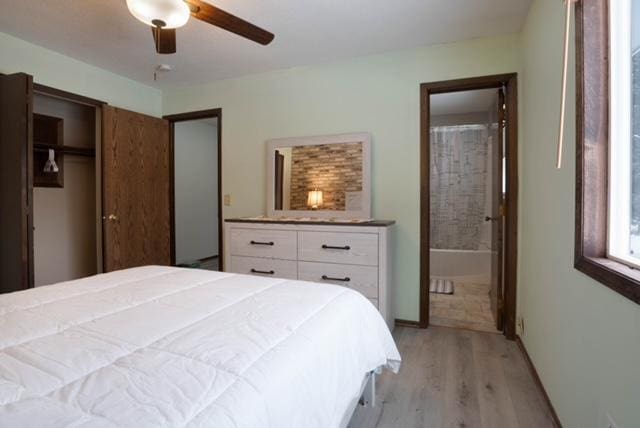 bedroom with light hardwood / wood-style floors, ceiling fan, and connected bathroom