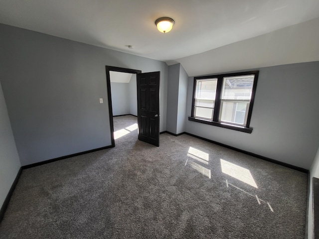 spare room with vaulted ceiling and carpet flooring