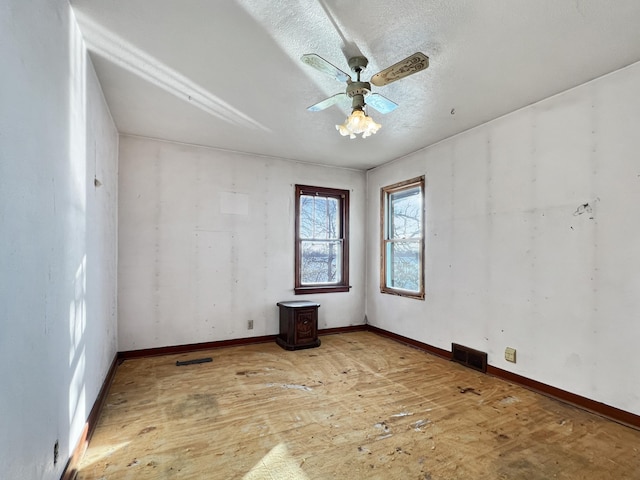 unfurnished room featuring a textured ceiling, hardwood / wood-style flooring, and ceiling fan