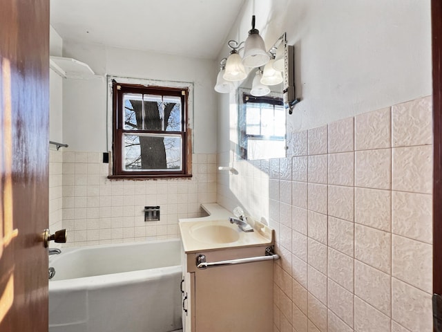 bathroom with vanity, tile walls, and a washtub