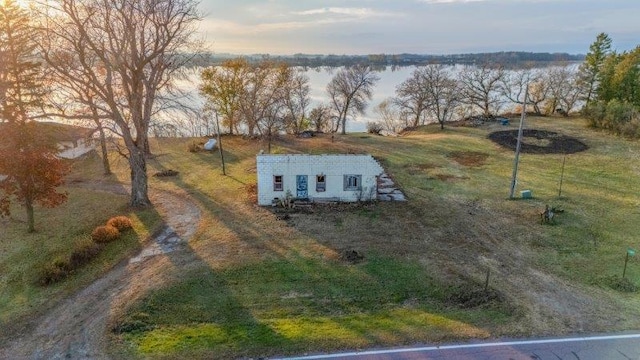 aerial view at dusk featuring a water view