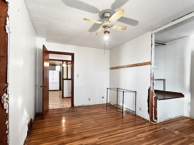 spare room with dark wood-type flooring, ceiling fan, and a textured ceiling