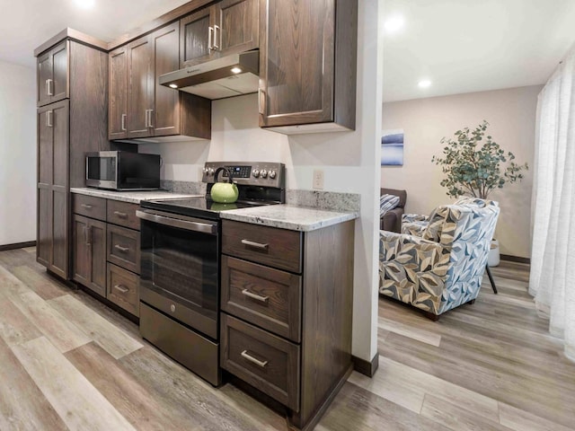 kitchen with light stone countertops, dark brown cabinets, stainless steel appliances, and light hardwood / wood-style flooring