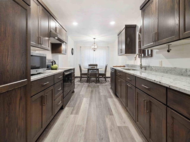 kitchen featuring appliances with stainless steel finishes, light hardwood / wood-style floors, dark brown cabinets, and sink