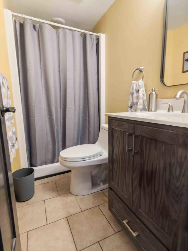 bathroom with toilet, vanity, and tile patterned floors