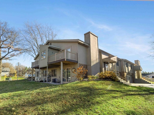 back of property featuring a lawn, cooling unit, and a garage