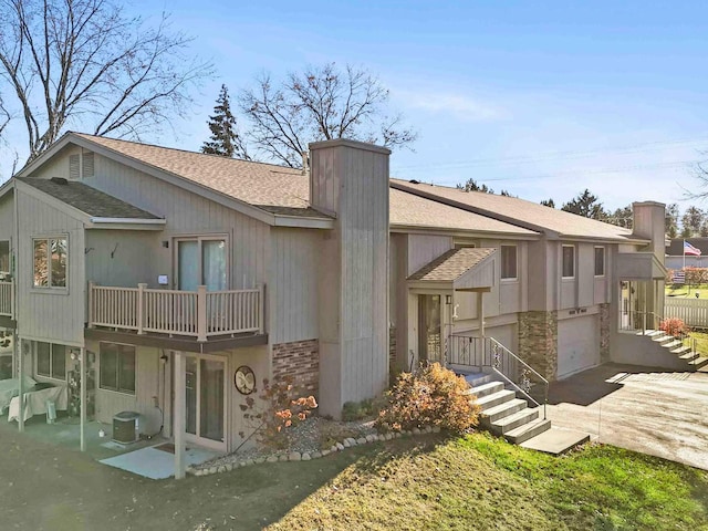 view of front of home featuring a garage and central air condition unit