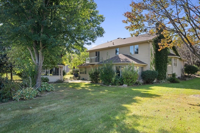 back of house featuring a sunroom and a yard