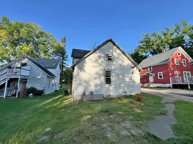 view of side of property with a deck and a yard