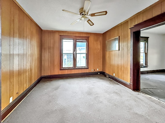 717 Jefferson Ave, Albert Lea, MN 56007 - spare room featuring healthy amount of natural light, baseboards, a ceiling fan, and wood walls