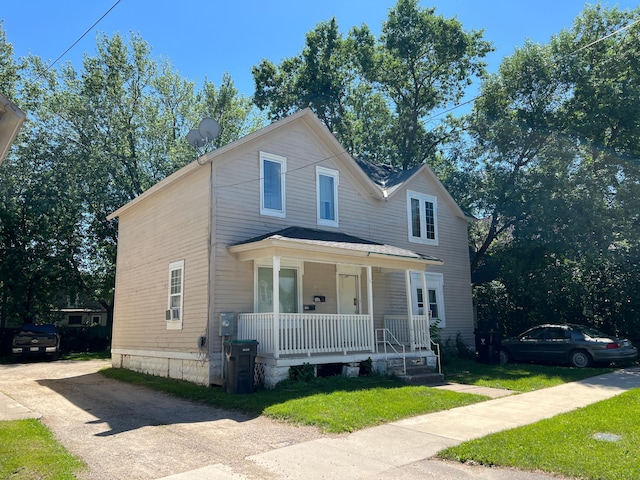 view of front of home with covered porch and a front lawn