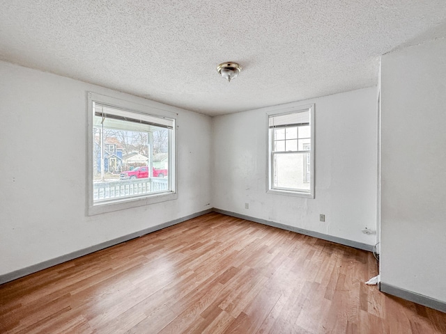 309 3rd Ave SW, Austin, MN 55912 - empty room featuring plenty of natural light, light wood-type flooring, and a textured ceiling