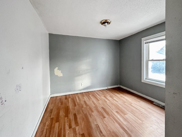 309 3rd Ave SW, Austin, MN 55912 - unfurnished room featuring hardwood / wood-style flooring and a textured ceiling