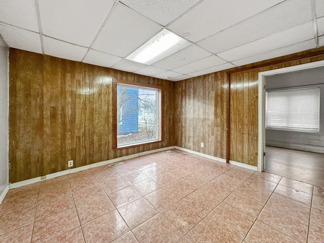 309 3rd Ave SW, Austin, MN 55912 - tiled spare room with wooden walls and a drop ceiling