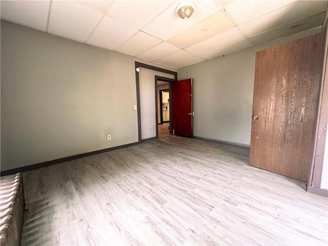 404 Main St, Austin, MN 55912 - empty room with a paneled ceiling, wood finished floors, radiator heating unit, and baseboards