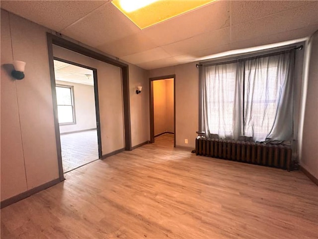 404 Main St, Austin, MN 55912 - empty room featuring radiator heating unit, light wood-type flooring, and baseboards