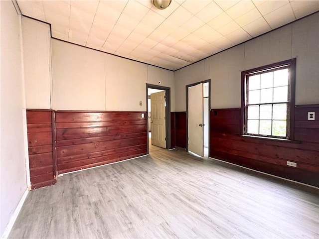 404 Main St, Austin, MN 55912 - empty room with wood finished floors, wooden walls, and wainscoting