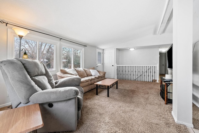 carpeted living room featuring beamed ceiling