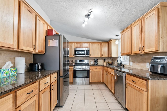 kitchen featuring sink, tasteful backsplash, light tile patterned floors, appliances with stainless steel finishes, and pendant lighting