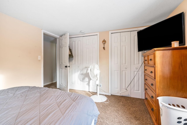 bedroom featuring carpet and two closets