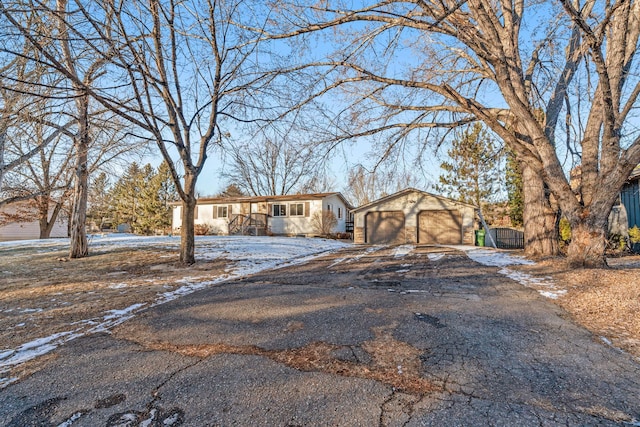 ranch-style home featuring a garage and an outbuilding