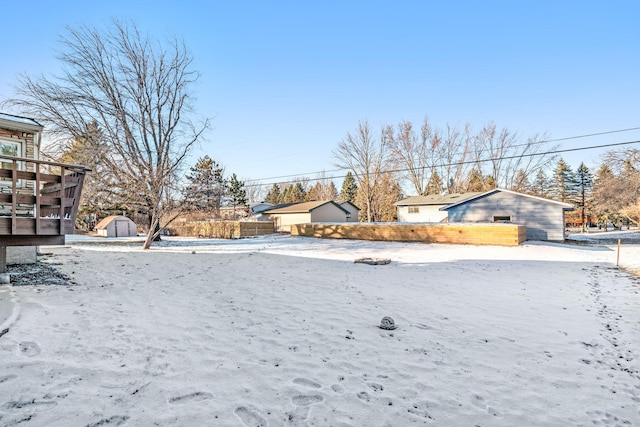 snowy yard with a storage shed