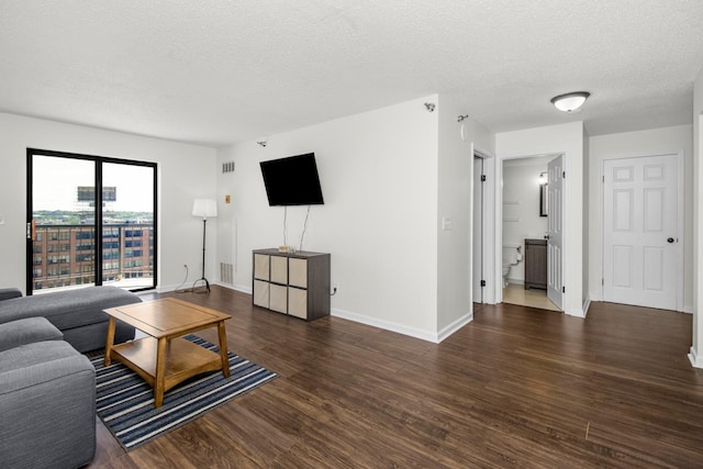 living room with dark wood-type flooring and a textured ceiling