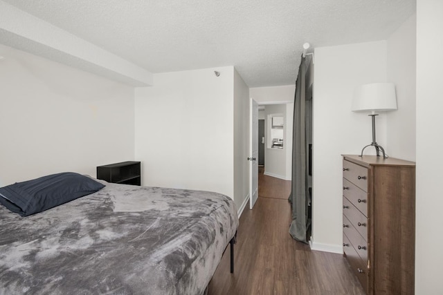 bedroom with dark wood-type flooring and a textured ceiling