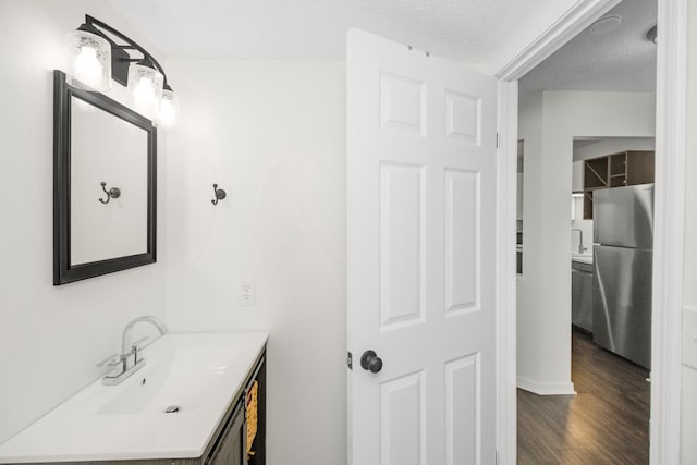 bathroom featuring wood-type flooring, a textured ceiling, and vanity