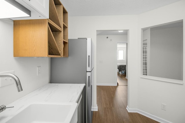 kitchen with dark hardwood / wood-style flooring, sink, and a textured ceiling