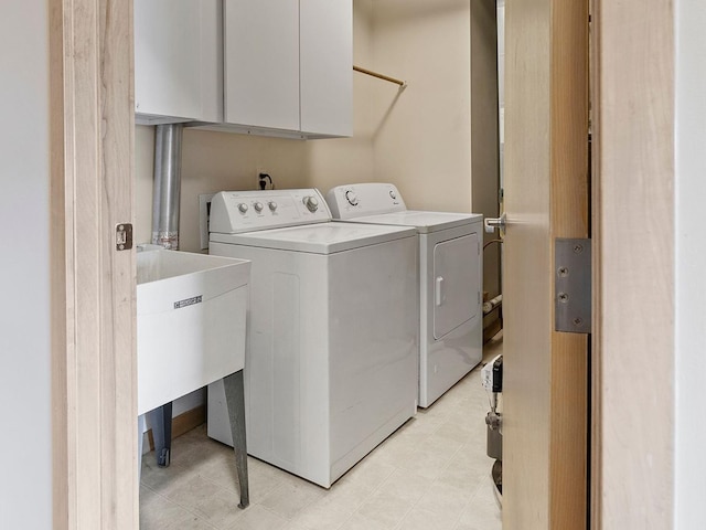 clothes washing area with cabinets and independent washer and dryer