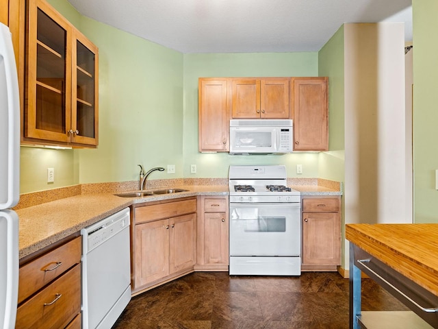 kitchen featuring light stone countertops, sink, light brown cabinets, and white appliances