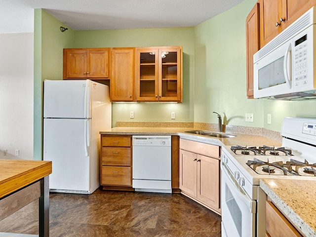 kitchen with sink, white appliances, and light stone countertops