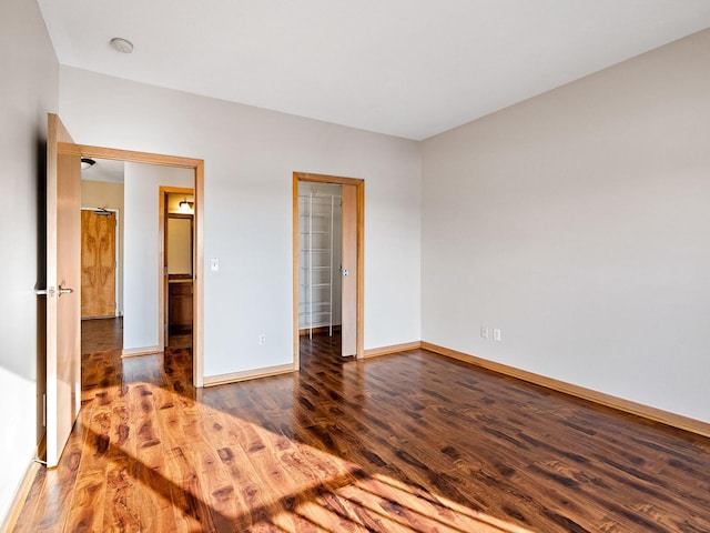 unfurnished bedroom with dark wood-type flooring and a closet